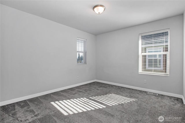 carpeted spare room featuring baseboards