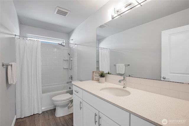 full bathroom featuring visible vents, shower / bathtub combination with curtain, toilet, vanity, and wood finished floors