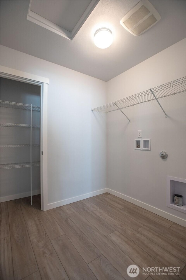 laundry area featuring hookup for a washing machine, visible vents, wood finished floors, laundry area, and baseboards