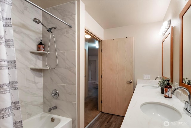 full bathroom featuring double vanity, shower / bathtub combination with curtain, wood finished floors, and a sink