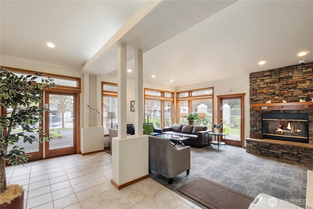 living room with a wealth of natural light, light tile patterned floors, a fireplace, and baseboards