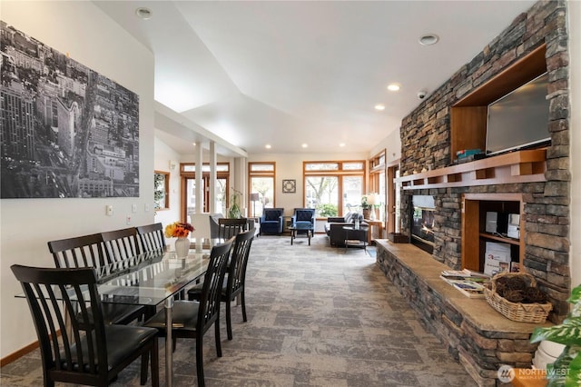 carpeted dining area with a stone fireplace, recessed lighting, and baseboards