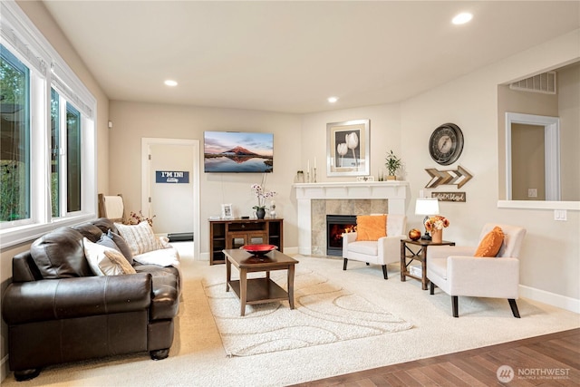 living area featuring visible vents, wood finished floors, a high end fireplace, recessed lighting, and baseboards