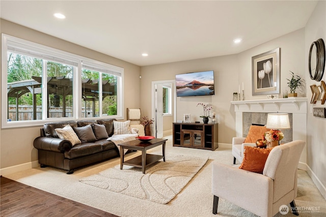 living room featuring recessed lighting, a fireplace, and baseboards