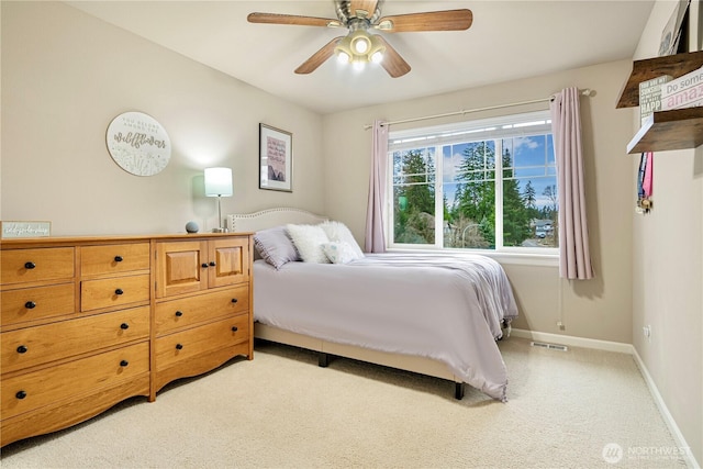 bedroom with light carpet, visible vents, baseboards, and ceiling fan