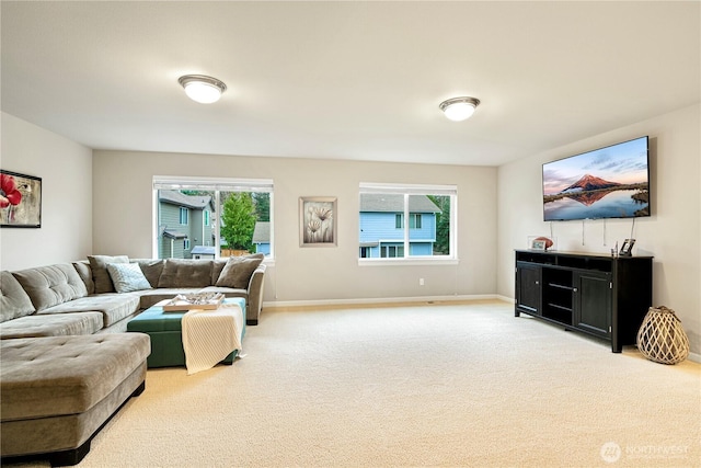 living area featuring light colored carpet and baseboards