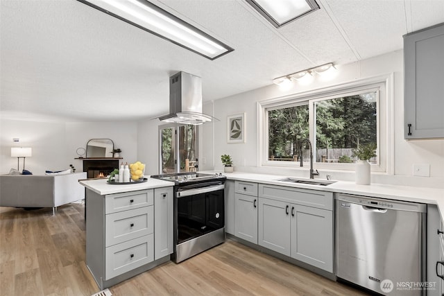 kitchen featuring a sink, gray cabinets, appliances with stainless steel finishes, and island range hood