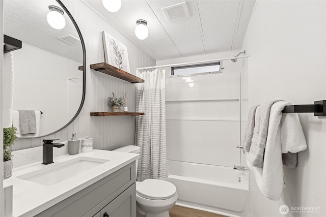 bathroom featuring visible vents, toilet, shower / bath combo with shower curtain, a textured ceiling, and vanity