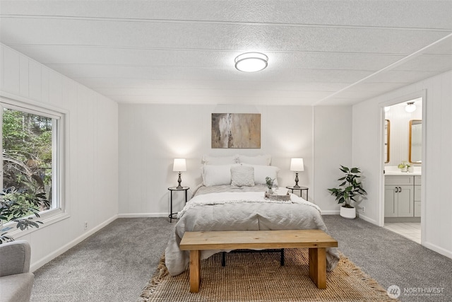 bedroom with connected bathroom, carpet floors, and baseboards