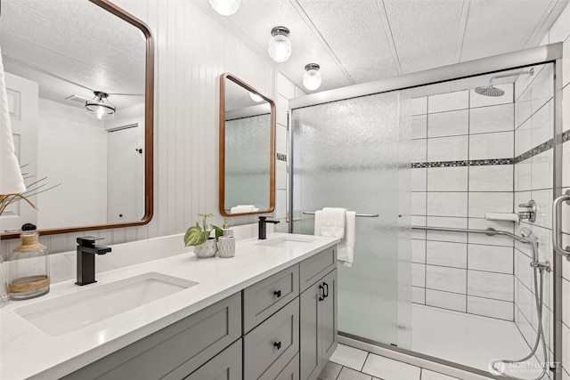 bathroom with a sink, a textured ceiling, and a stall shower