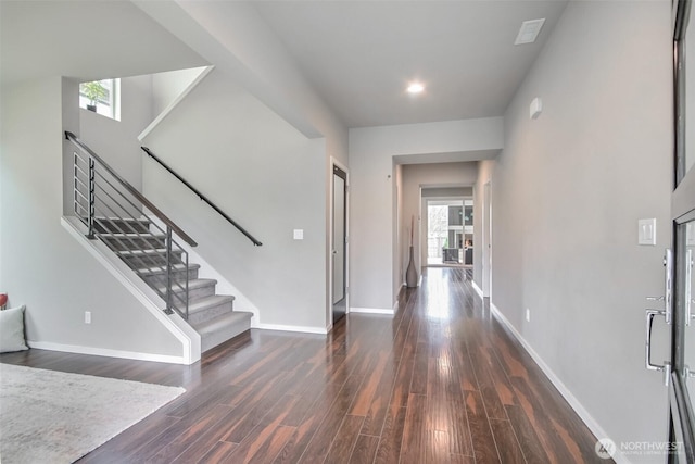 foyer entrance with stairway, wood finished floors, and baseboards