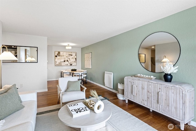 living area with baseboards and wood finished floors