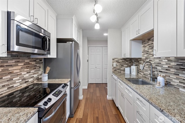 kitchen featuring white cabinets, dark wood finished floors, stainless steel appliances, and a sink