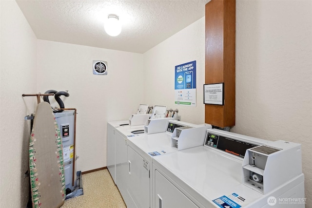 common laundry area featuring baseboards, visible vents, electric water heater, a textured ceiling, and separate washer and dryer