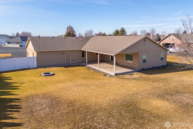 rear view of house with an outdoor fire pit, fence, a lawn, a gate, and a patio area