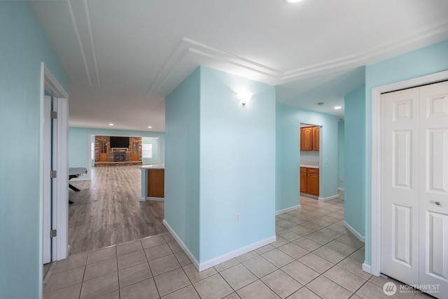 hall featuring recessed lighting, light tile patterned flooring, and baseboards