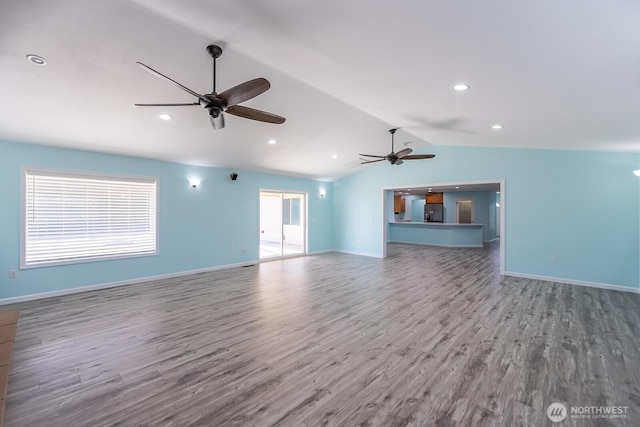 unfurnished living room with lofted ceiling, baseboards, a ceiling fan, and wood finished floors