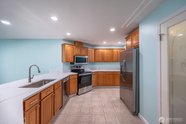 kitchen featuring brown cabinets, stainless steel appliances, a sink, and recessed lighting