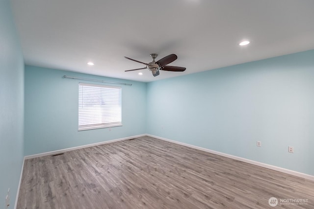 spare room with ceiling fan, recessed lighting, wood finished floors, and baseboards