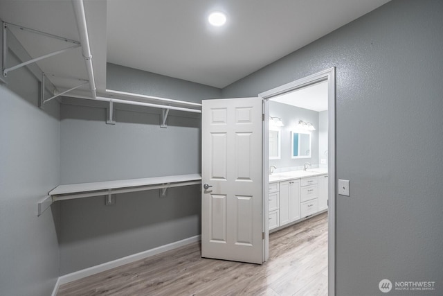 spacious closet featuring a sink and light wood-style flooring