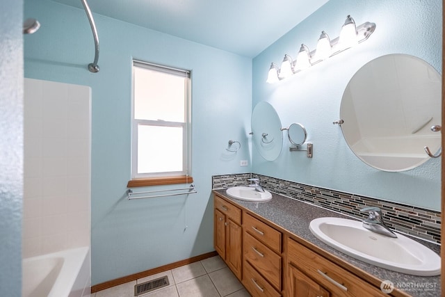 bathroom with tasteful backsplash, visible vents, a sink, and tile patterned floors