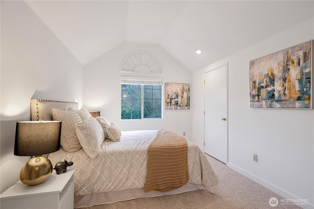 carpeted bedroom with lofted ceiling and baseboards