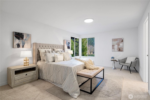 bedroom with baseboards and light colored carpet