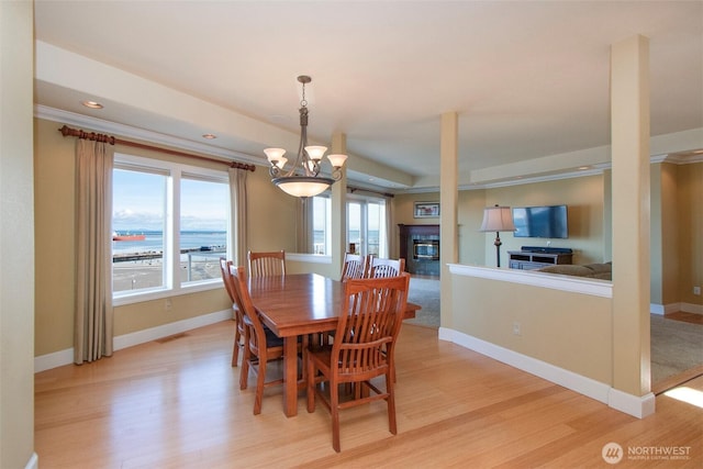 dining room featuring light wood-style flooring, a chandelier, baseboards, and visible vents
