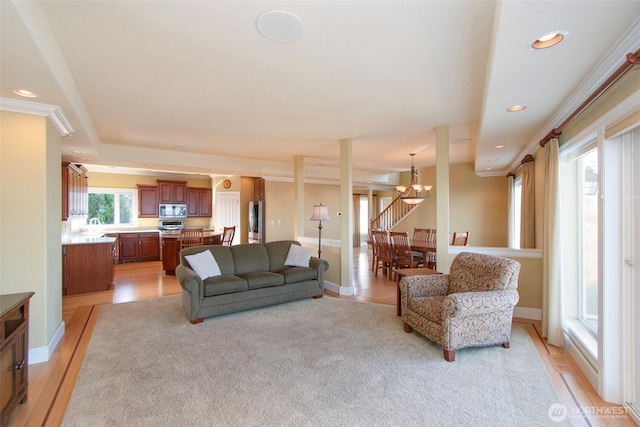 living room featuring recessed lighting, light wood-style flooring, baseboards, and an inviting chandelier