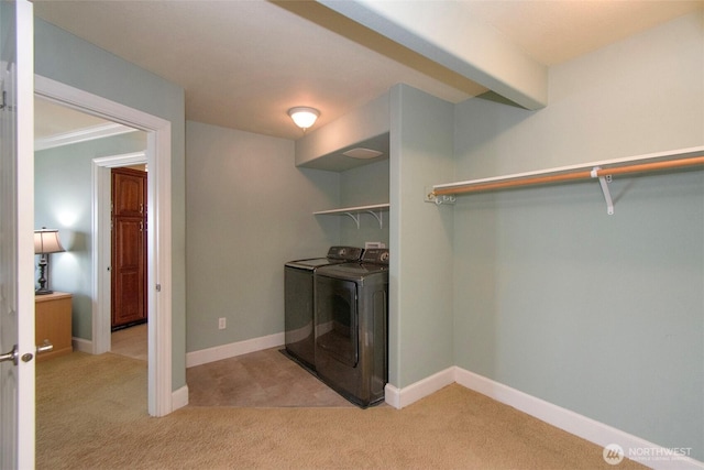 laundry room featuring separate washer and dryer, light colored carpet, and baseboards