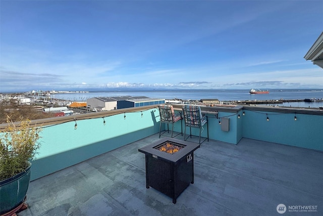 view of patio / terrace featuring a water view and an outdoor fire pit