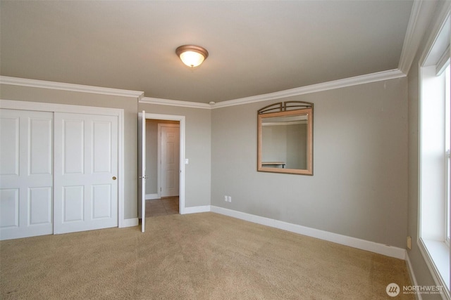 unfurnished bedroom with crown molding, carpet floors, baseboards, and a closet