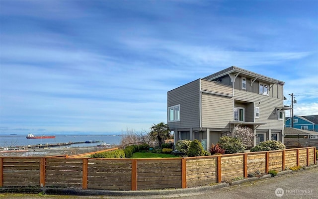 exterior space featuring fence and a water view