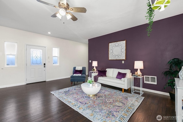 living area with baseboards, visible vents, ceiling fan, and wood finished floors