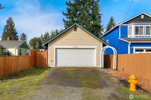 detached garage featuring fence