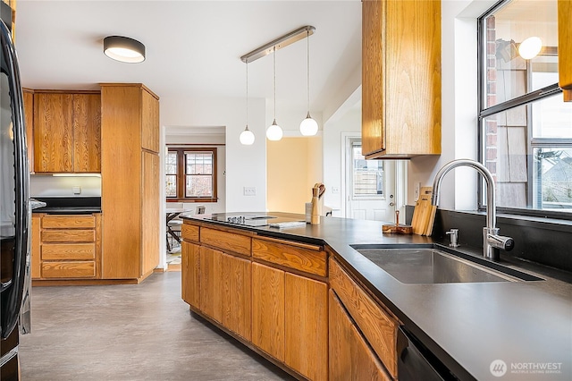 kitchen featuring a sink, dark countertops, and brown cabinetry