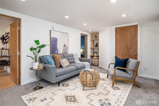 carpeted living area featuring recessed lighting and baseboards