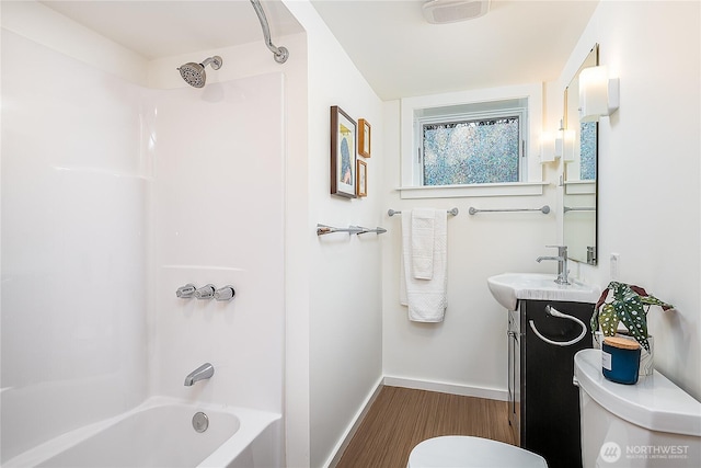 full bath featuring baseboards, shower / washtub combination, toilet, wood finished floors, and vanity