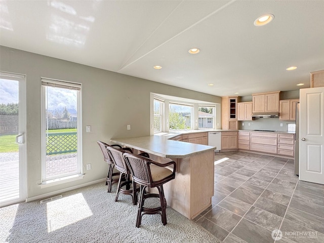 602 Mccomb Rd, Sequim, WA 98382 - kitchen with a peninsula, light brown cabinetry, recessed lighting, a breakfast bar, and dishwasher