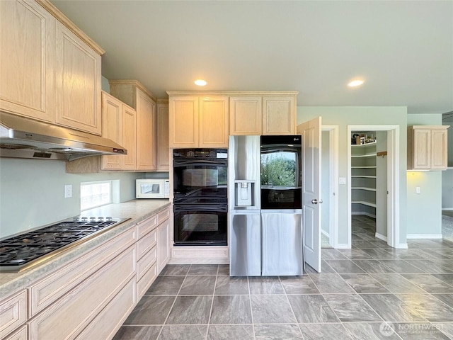 602 Mccomb Rd, Sequim, WA 98382 - kitchen with white microwave, light countertops, gas cooktop, under cabinet range hood, and dobule oven black