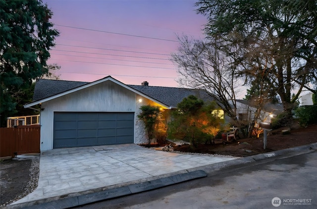 ranch-style home featuring a garage, roof with shingles, and driveway