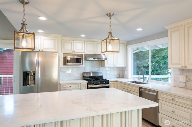 kitchen featuring light stone counters, stainless steel appliances, cream cabinets, a sink, and under cabinet range hood