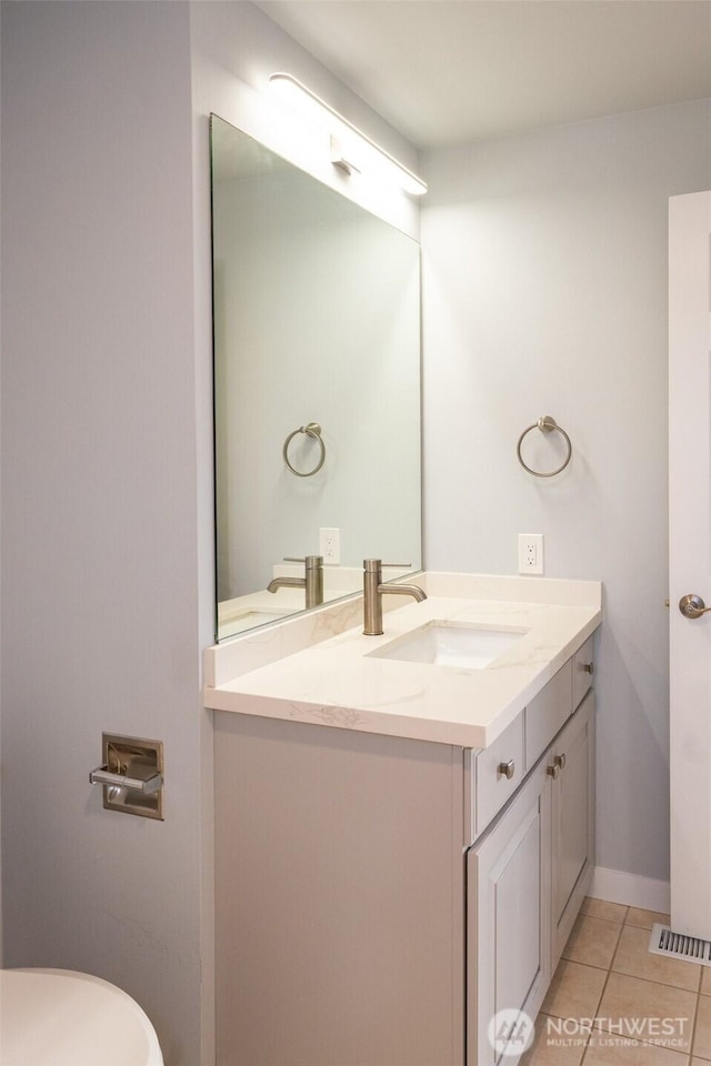 half bath with visible vents, baseboards, toilet, tile patterned flooring, and vanity