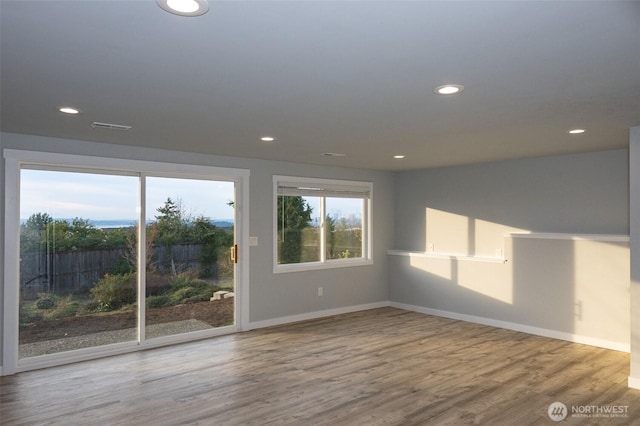 unfurnished room featuring recessed lighting, visible vents, baseboards, and wood finished floors