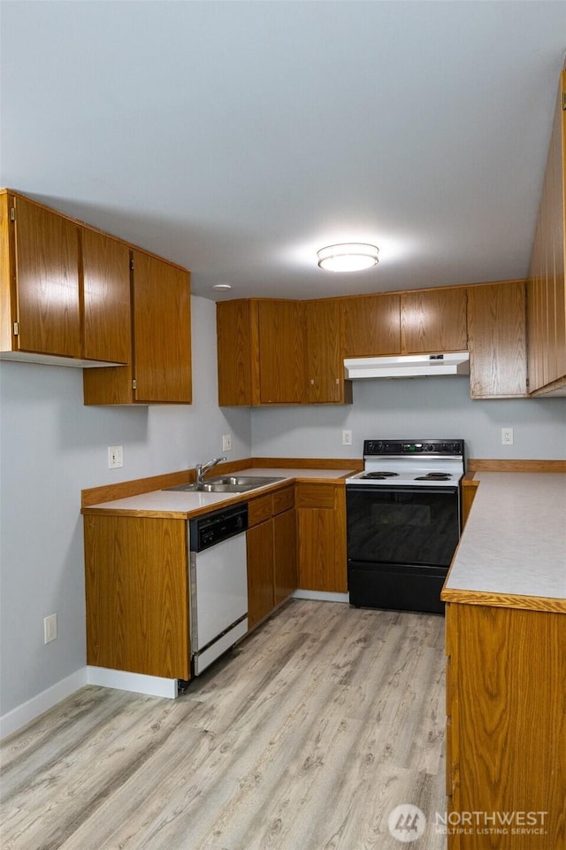 kitchen with brown cabinets, electric range, white dishwasher, a sink, and under cabinet range hood