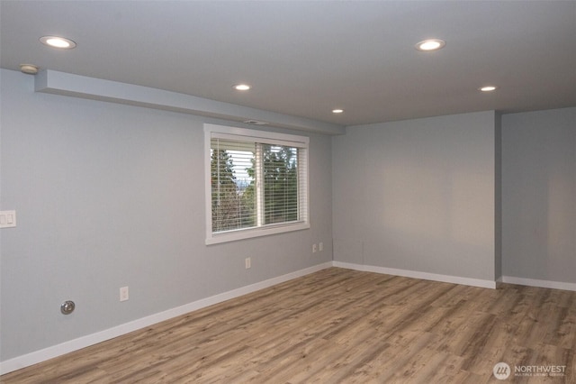 unfurnished room featuring recessed lighting, wood finished floors, and baseboards