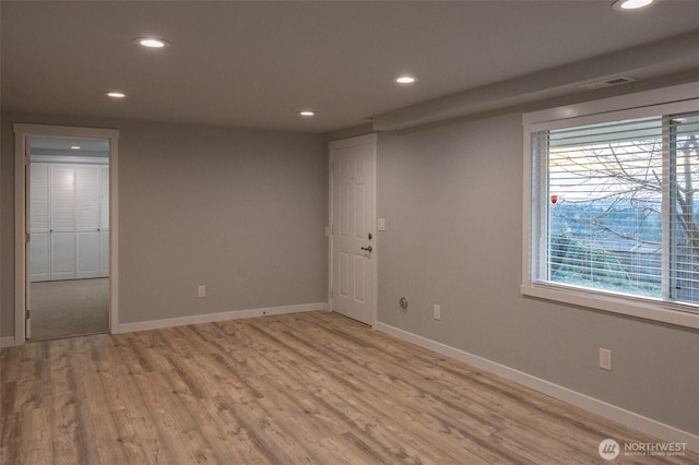 spare room featuring baseboards, light wood-style flooring, and recessed lighting