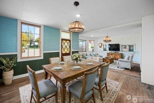 dining space with a notable chandelier, baseboards, and wood finished floors