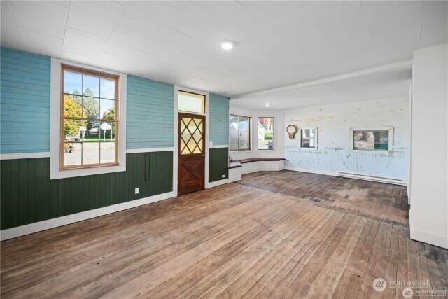 interior space with hardwood / wood-style flooring, baseboards, baseboard heating, and recessed lighting