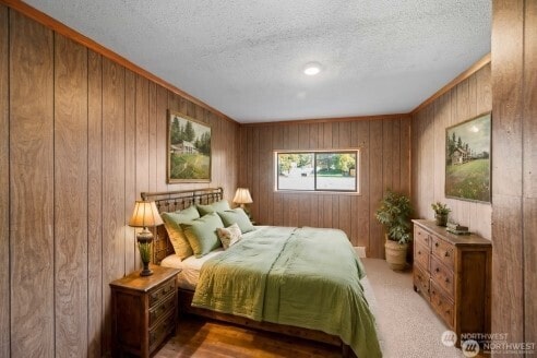 bedroom with a textured ceiling and wooden walls